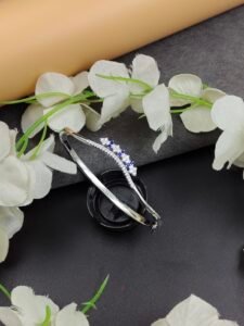 Blue Floral Silver Kada with flower-inspired blue stone motifs, sparkling clear stone detailing, and a slim silver-toned design displayed on a jewellery stand.